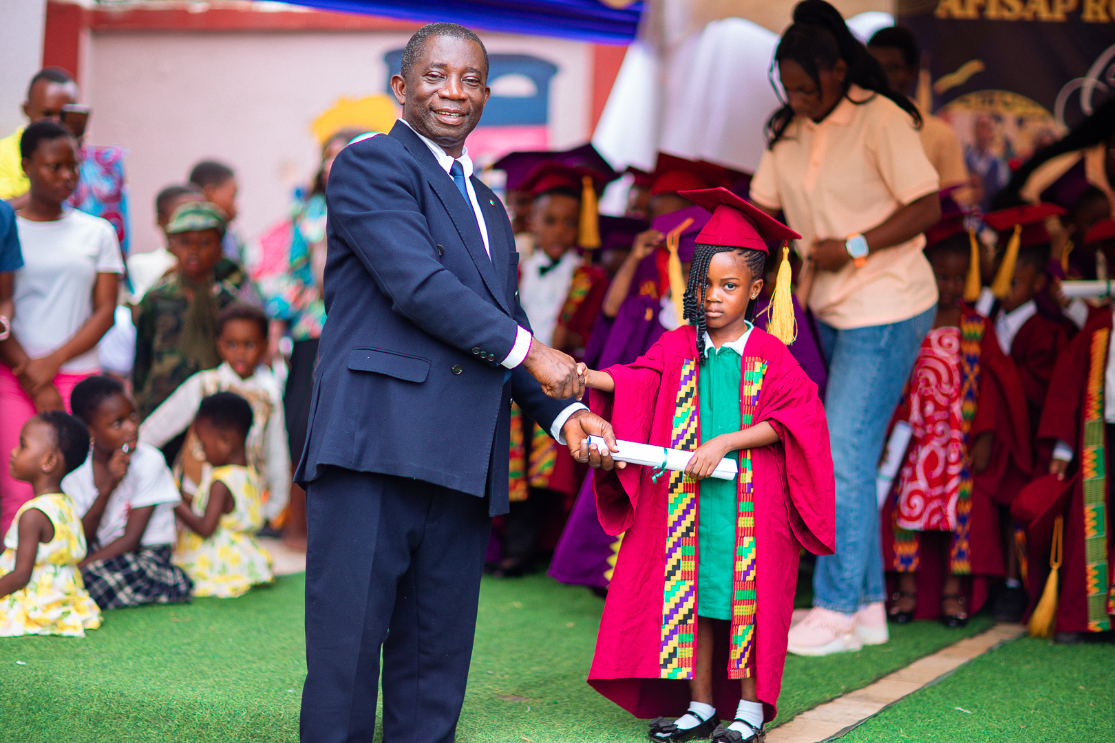 Mr. Amofa John presenting a graduation certificate to a final graduand at Afisap Royal Academy